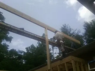 Carpenter setting a ridge beam over a new addition frame — Ice Dam Removal by Roofing Brothers in Danevang