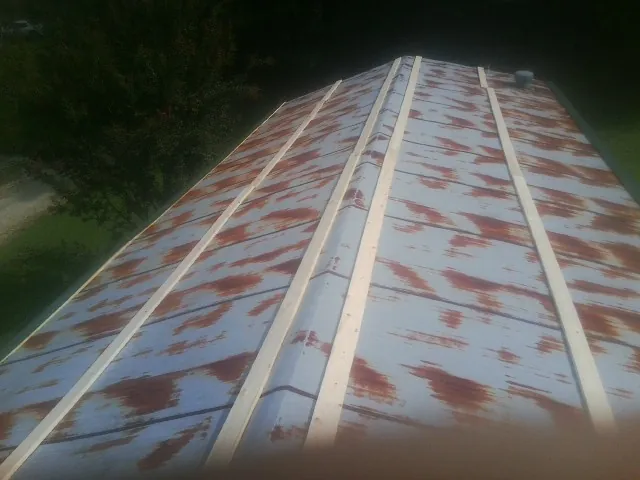 Rusted metal roof panels with new wood purlins before replacement — Storm Damage Roof Repair in Danevang by Roofing Brothers