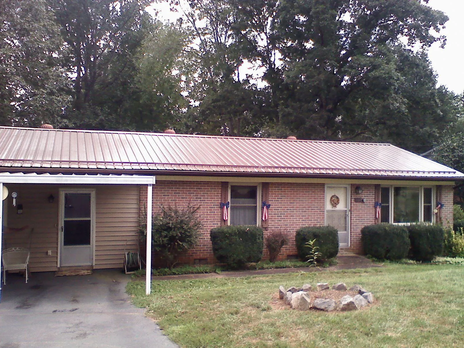 Bronze metal roof and carport on a brick ranch home — Roof Repair work by our crew in Danevang